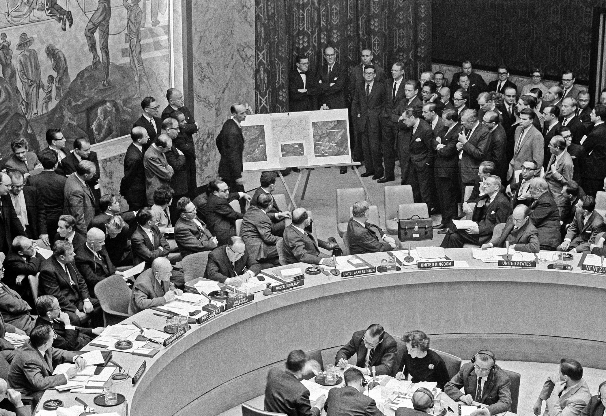 Adlai Stevenson II shows aerial photos of Russian missiles in Cuba to the United Nations Security Council in the presence of USSR ambassador Valerian Zorin. 